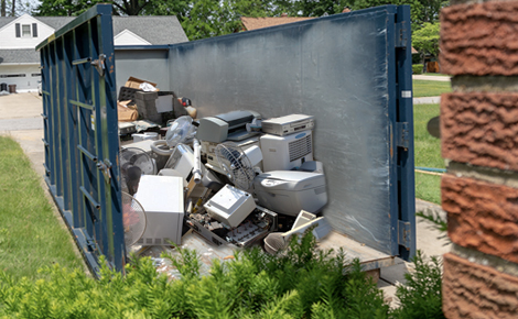 一堆电子垃圾在一个滚动的垃圾箱里