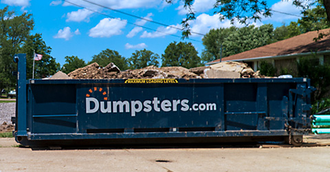 Man Standing Next to 12 Yard Dumpster with Dimensions 14 feet x 7.5 feet x 4 feet