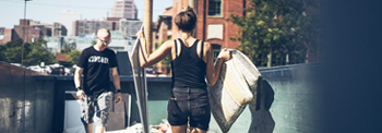 People Walking Items Into a Roll Off Dumpster.