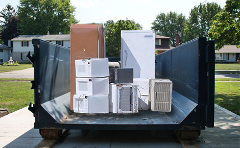 Dumpster full of assorted appliances.