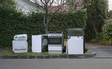 Broken appliances on the curb for bulk pickup.