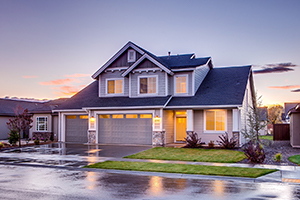 A two-story home in front of a sunset.