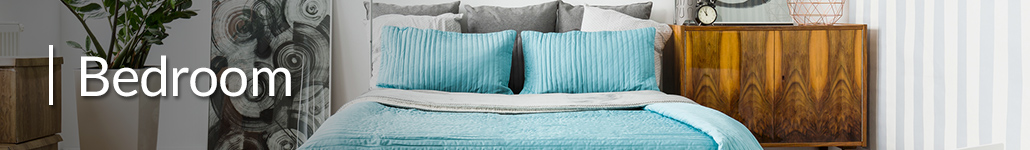 Bed with blue and white striped pillows, a wooden nightstand and a plant.