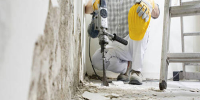 Worker Using Jackhammer to Demolish Floor
