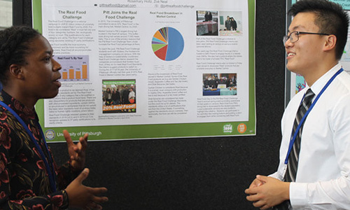 A student presents his findings to a professor at the Association for the Advancement of Sustainability in Higher Education conference.