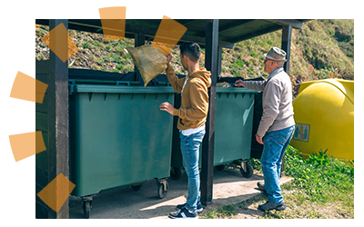 Two men using a dumpster to help clean up.