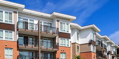 Multi-story, brick apartment building complex with balconies. 