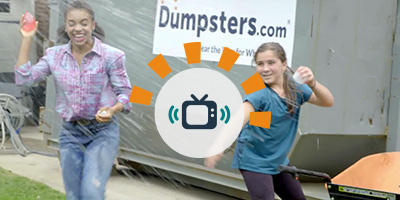 Kids throwing water balloons in front of Dumpsters.com dumpster.