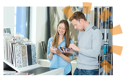 Young couple selecting tile options while holding a calculator to budget the cost.