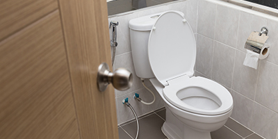 A white toilet in a tiled bathroom.