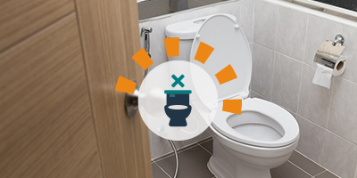 A white toilet in a tiled bathroom.