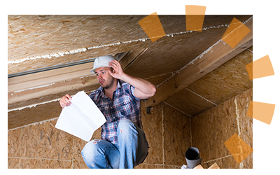 Man in bare attic looking at a piece of paper.