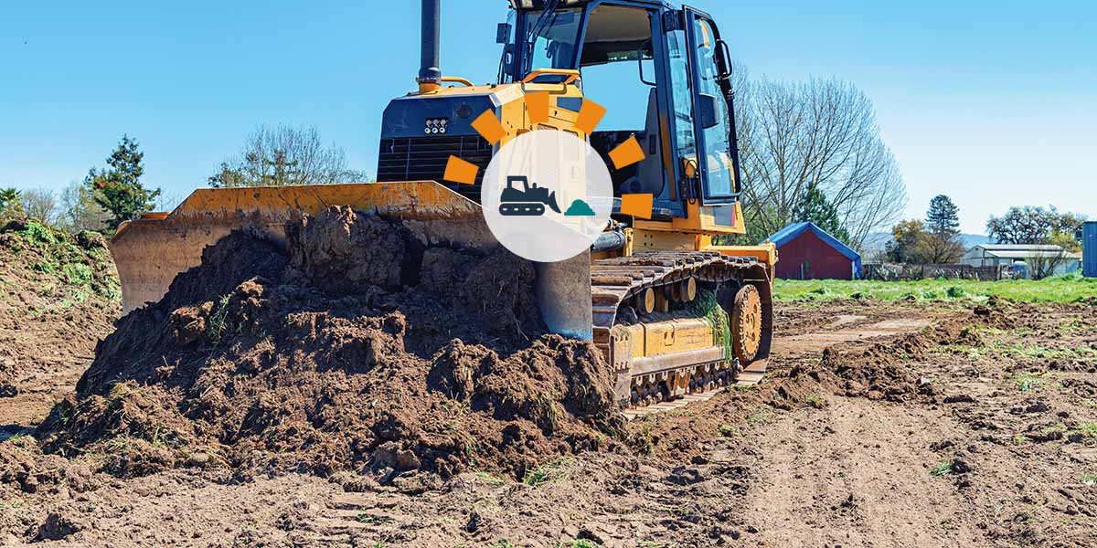 A bulldozer clearing and leveling land. 