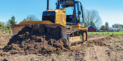 A bulldozer clearing and leveling land. 