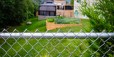 The backyard of a home with chain link fencing.