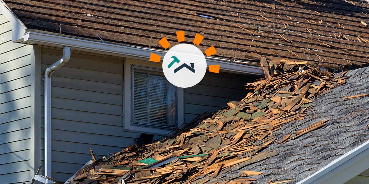 A two-story home with the upper story's roof shingles removed.