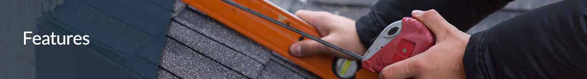 A person using a level to measure the pitch of a roof.