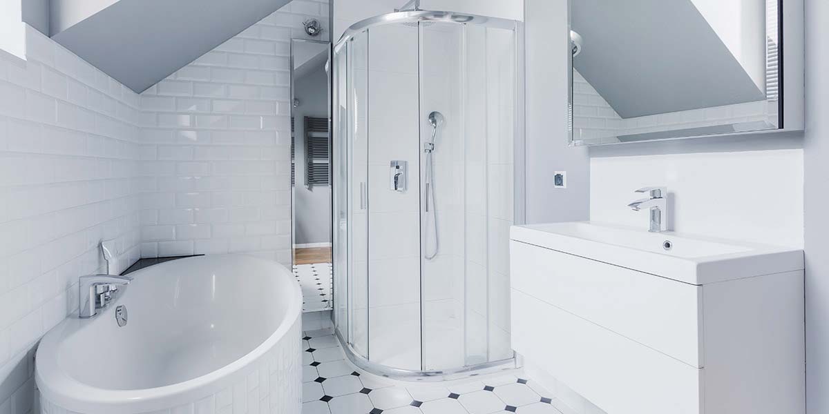 small bathroom with white tile and sloped ceiling