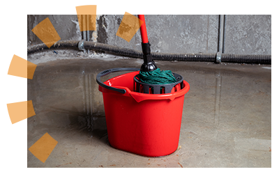 A mop and bucket resting on a concrete floor. 