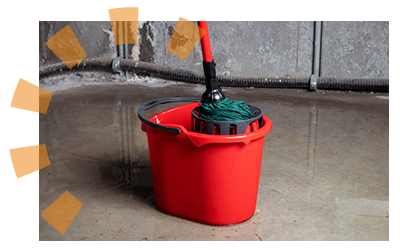 A mop and bucket resting on a concrete floor.