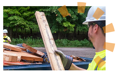 A man throwing debris into a Dumpsters.com dumpster.