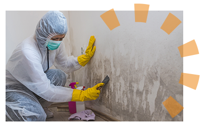 A person in safety gear cleaning adhesive off of walls 