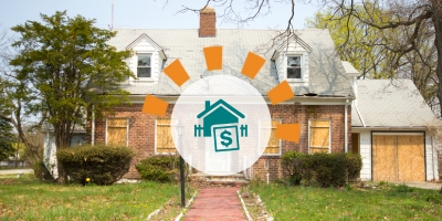 A foreclosed property with boarded up windows and doors and an overgrown yard.