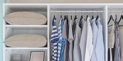 Hanging clothes and other home items neatly organized in a closet.