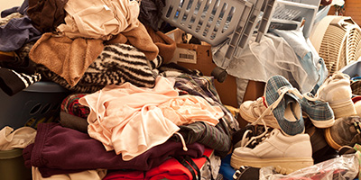 A pile of clothes, shoes, baskets and boxes.