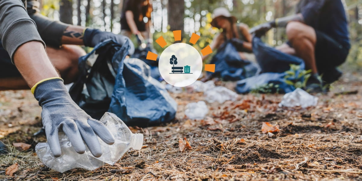 People picking up litter in a wooded area.