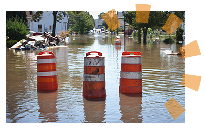 Orange construction barrels are partially submerged in a flooded area.