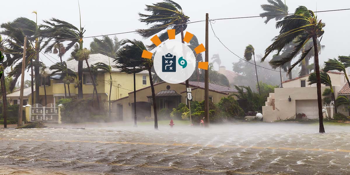 A hurricane blows through a residential neighborhood as the road starts to flood.