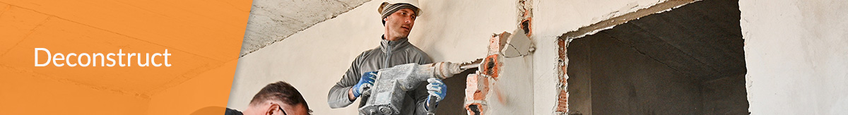 Workers manually tear down an interior wall.