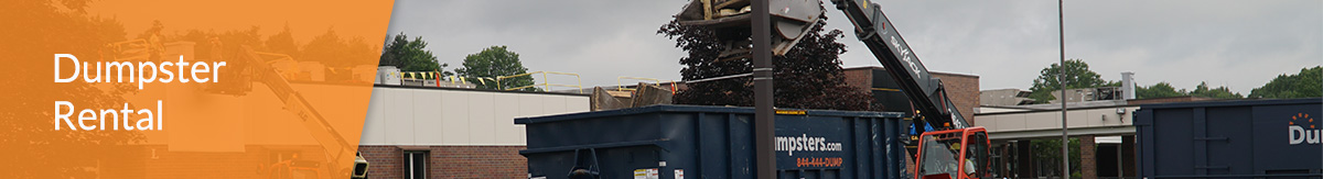 A blue Dumpsters.com roll off dumspter is loaded with contruction debris.