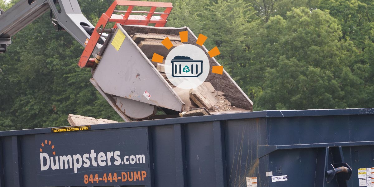 Crane Dumping Wood in Roll Off Dumpster.