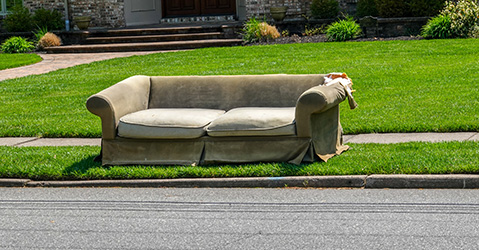 An old couch sitting on the side of the road
