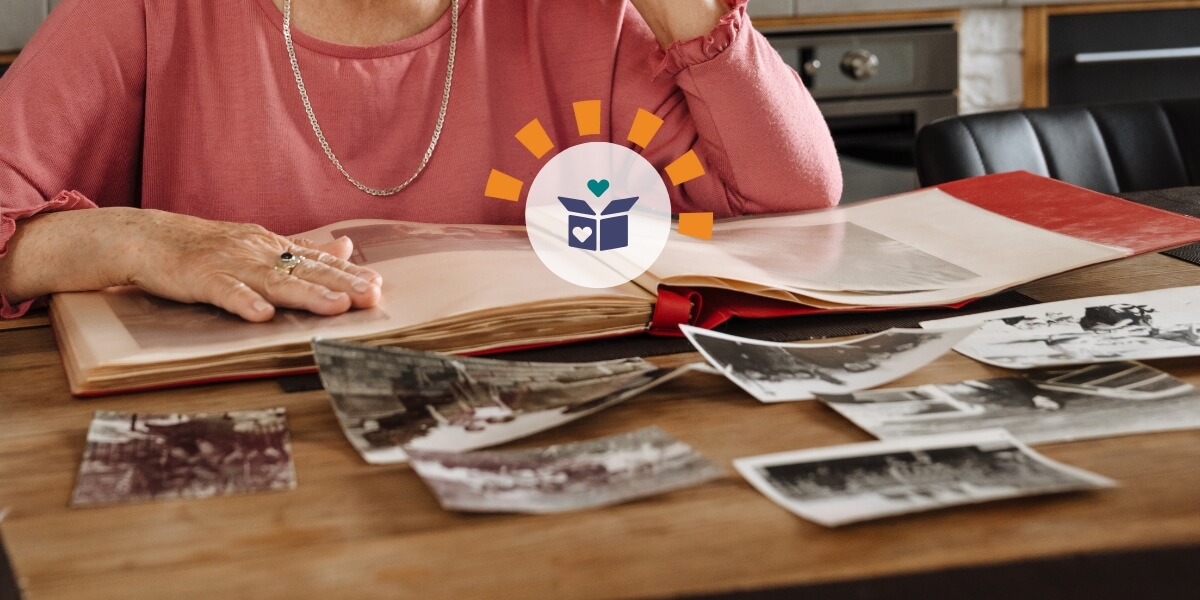Woman wearing pink shirt declutters sentimental photographs.