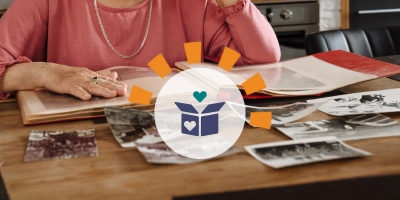 Woman wearing pink shirt declutters sentimental photographs.