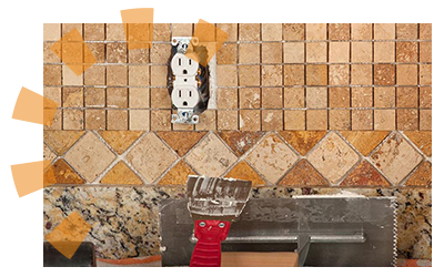 A red putty knife leaning against a tile backsplash ready for demolition.