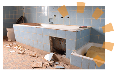 A person demolishing the tile surrounding their old bathtub. 