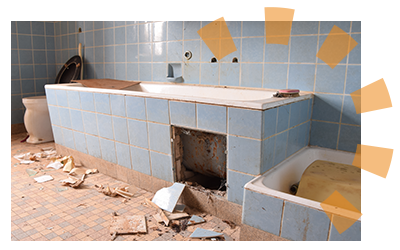 A person demolishing the tile surrounding their old bathtub.