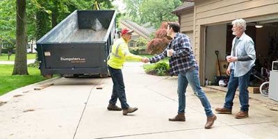 Dumpster.com Roll Off Truck Driver Matt Snyder Shakes Hands With a Customer During a Roll Off Dumpster Delivery.