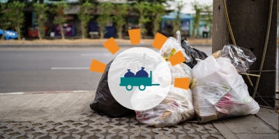 A pile of filled trash bags sitting on the side of the street.