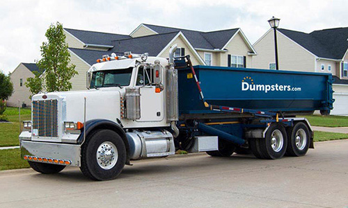Truck hauling away a Dumpsters.com dumpster.