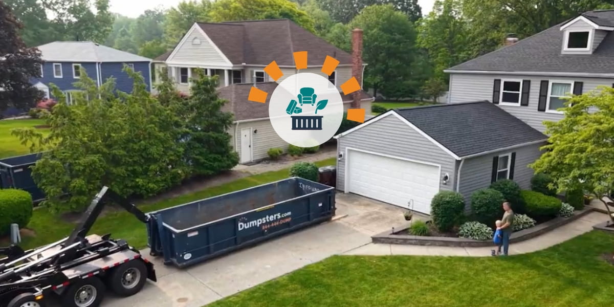A father and son standing outside their home watching a truck deliver a roll off dumpster.