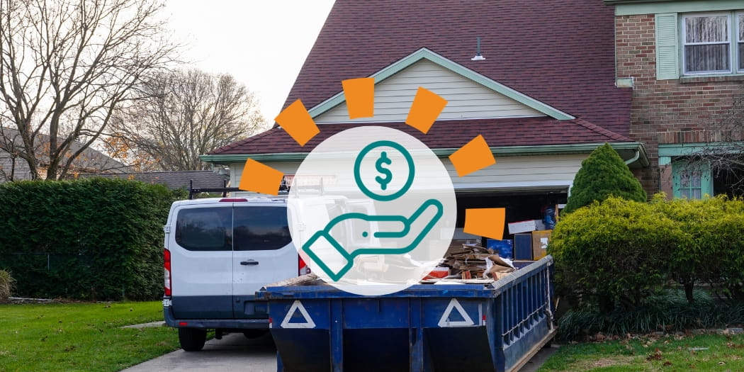 Dumpster filled with debris in driveway next to van.