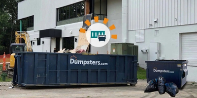 Dumpsters.com Roll Off Dumpster and Front Load Dumpster in Front of Building