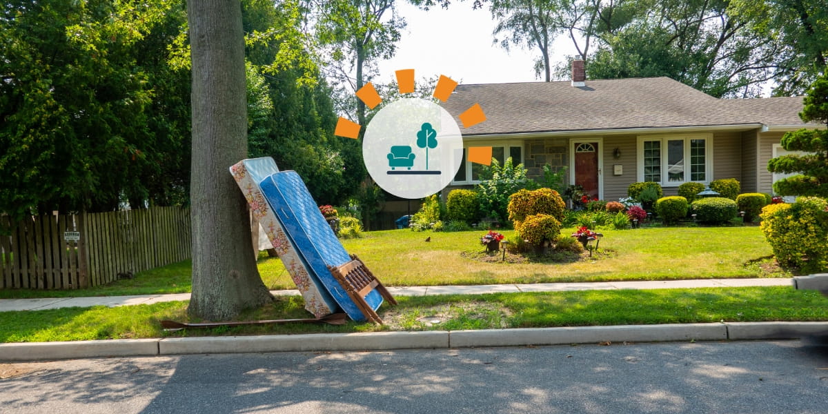 A mattress, box spring and bed frame sitting on a curb in front of a house.