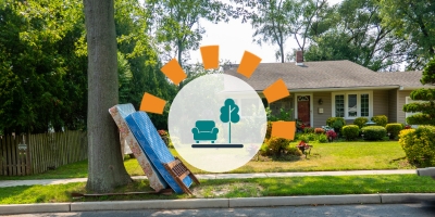 A mattress, box spring and bed frame sitting on a curb in front of a house.