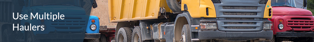 Multiple dump trucks parked at a construction site.